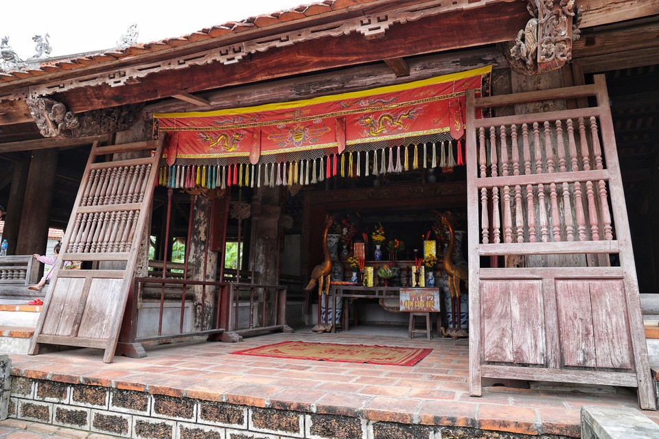 Gian giữa đại đình có cửa võng hình lưỡng long chầu nguyệt sơn son thiếp vàng. Một ban thờ lớn trang trí bằng tượng rồng, hổ phù... (Ảnh: Xuân Mai/Vietnam+)