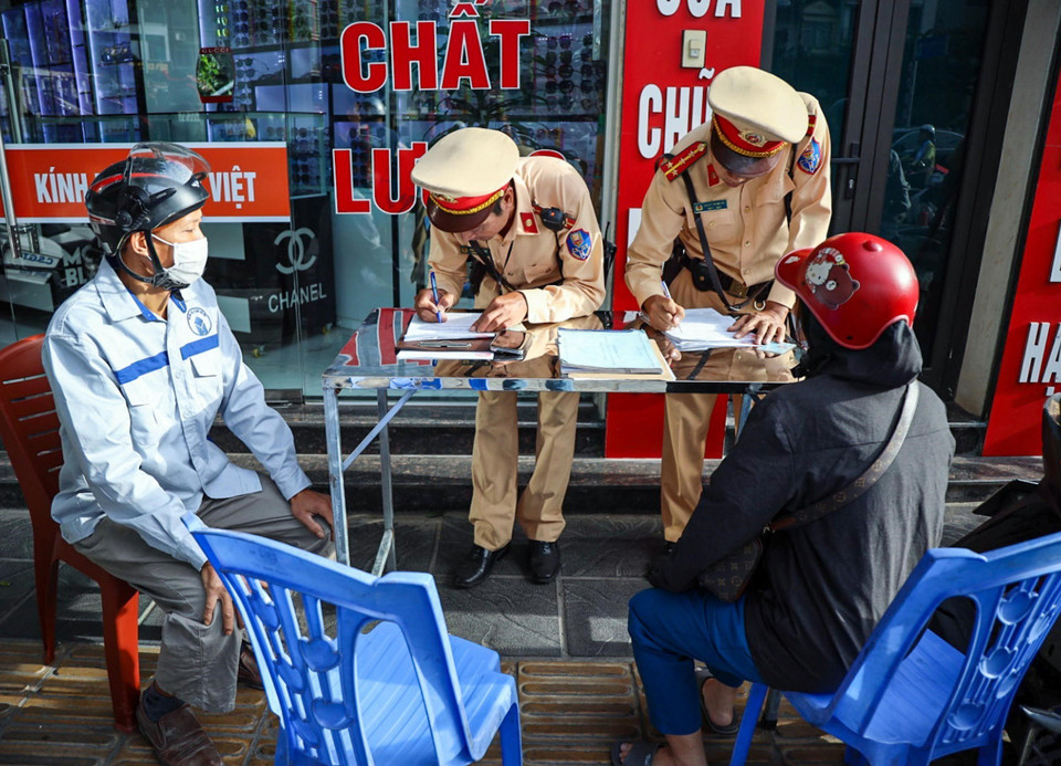 Cán bộ, chiến sĩ đội CSGT số 4 lập biên bản xử phạt các trường hợp điều khiển xe máy vào đường Vành đai 2 trên cao. (Ảnh: Phạm Kiên/TTXVN)