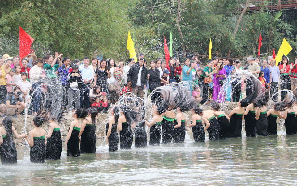 Màn hất tóc ấn tượng của các cô gái Thái tại lễ hội gội đầu. (Ảnh: Văn Oanh/TTXVN)