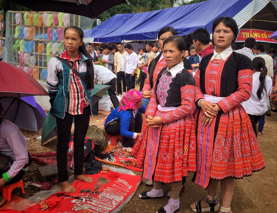 Những cô gái H'Mông xúng xính đi chợ phiên với trang phục dân tộc truyền thống. (Ảnh: Xuân Mai/Vietnam+)