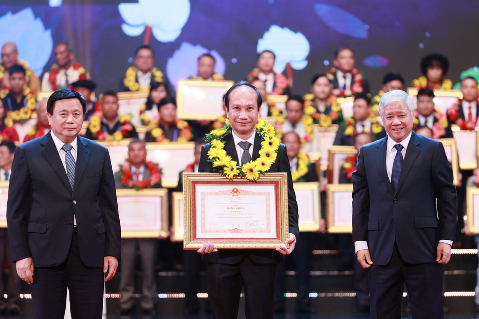 Ủy viên Bộ Chính trị, Giám đốc Học viện Chính trị Quốc gia Hồ Chí Minh Nguyễn Xuân Thắng và Bí thư Trung ương Đảng, Chủ tịch Ủy ban Trung ương Mặt trận Tổ quốc Việt Nam Đỗ Văn Chiến trao Bằng khen của Thủ tướng và hoa cho điển hình tiên tiến tiêu biểu. (Ảnh: Dương Giang/TTXVN)