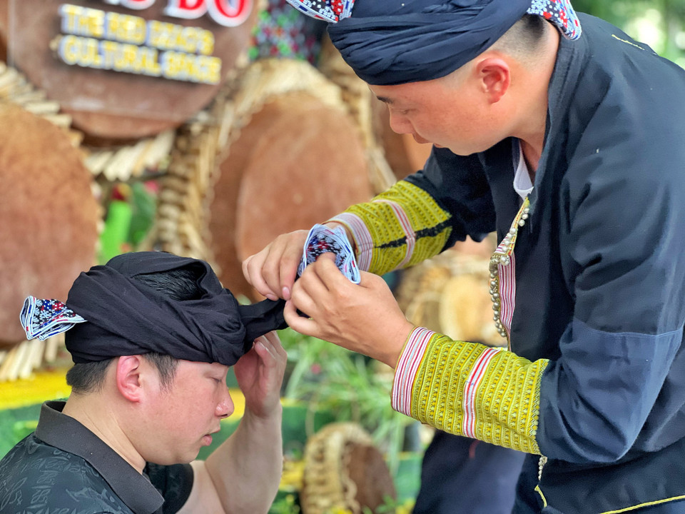 Các chàng trai chỉnh trang để chuẩn bị biểu diễn dân ca, dân vũ. (Ảnh: Mai Mai/Vietnam+)