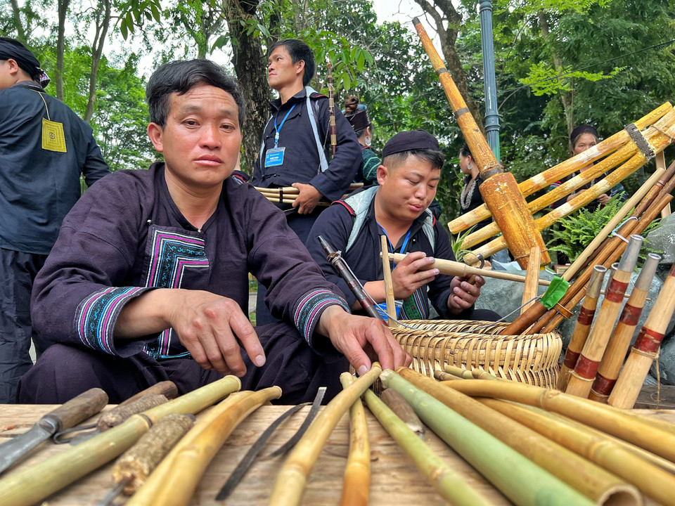 Các chàng trai người Mông trổ tài làm khèn, một nhạc cụ truyền thống độc đáo. (Ảnh: Mai Mai/Vietnam+)