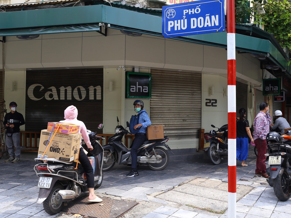 Nhiều người dân chờ đưa đồ tiếp tế vào khu vực bị phong tỏa phố Phủ Doãn. (Ảnh: Hoàng Hiếu/TTXVN)