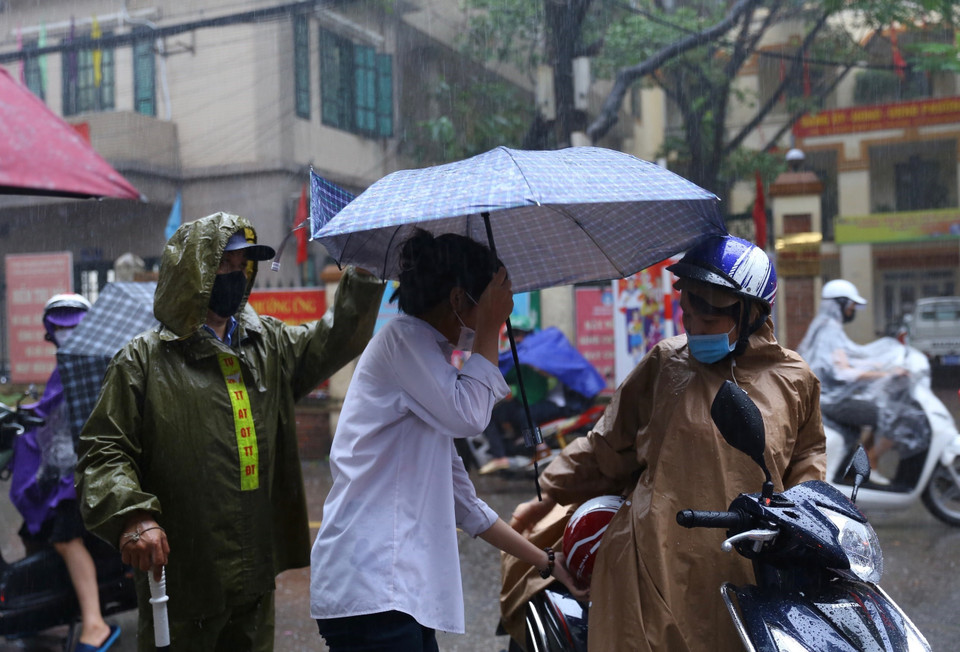 Lực lượng công an giúp thí sinh vào điểm thi tại Trường THCS Hà Huy Tập. (Ảnh: Hoàng Hiếu/TTXVN)