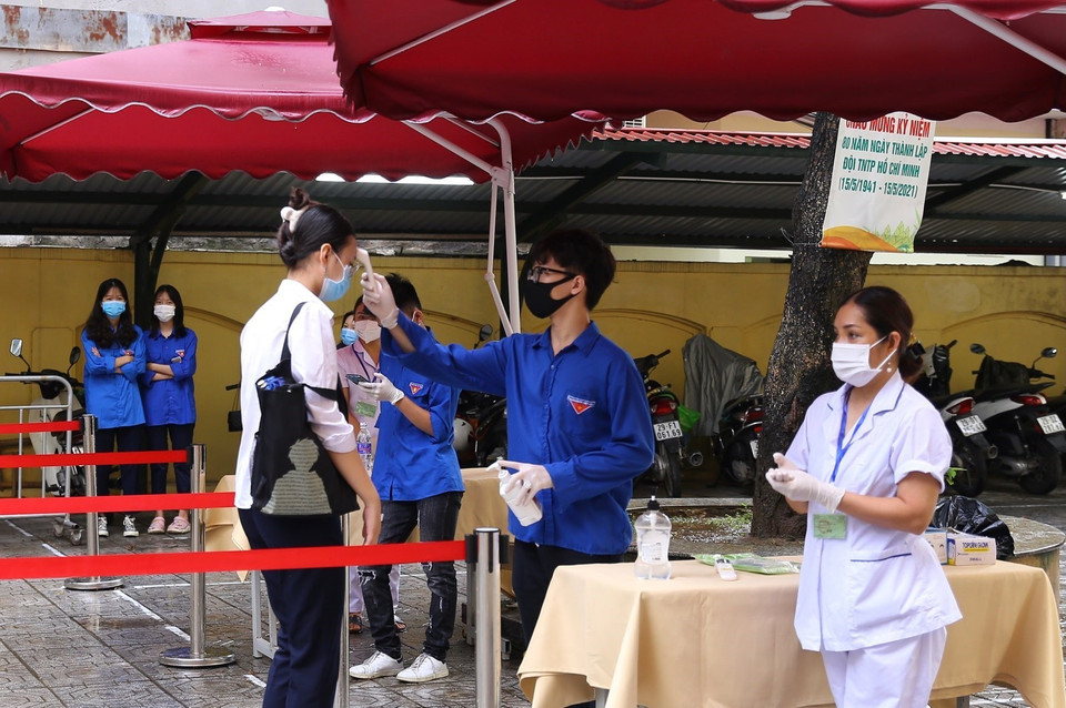  Đo thân nhiệt thí sinh trước khi vào phòng thi tại điểm thi Trường THCS Hà Huy Tập (quận Hai Bà Trưng). (Ảnh: Hoàng Hiếu/TTXVN)