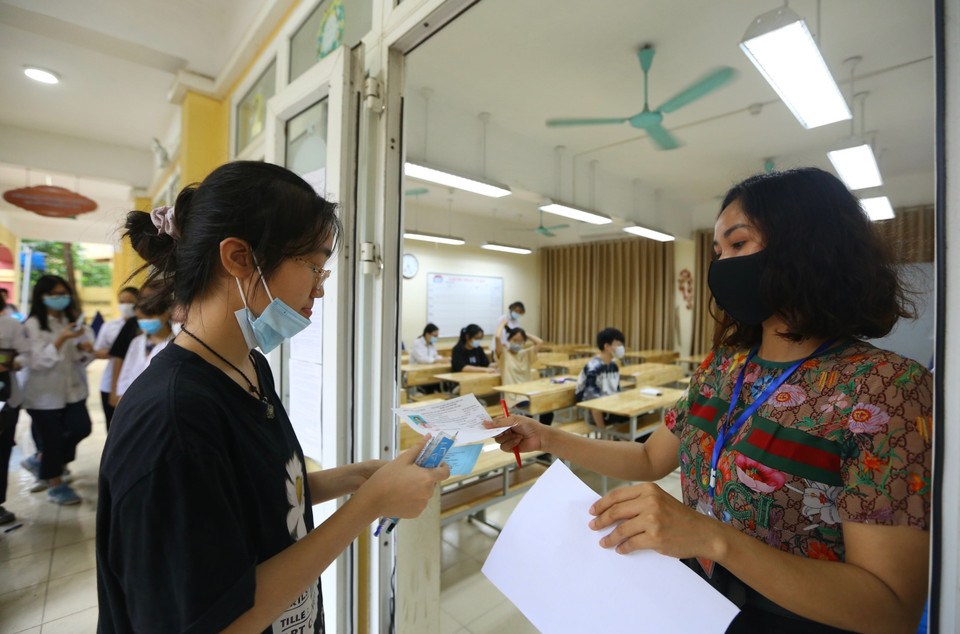  Thí sinh làm thủ tục trước khi vào phòng thi tại điểm thi Trường THCS Hà Huy Tập, quận Hai Bà Trưng). (Ảnh: Hoàng Hiếu/TTXVN)