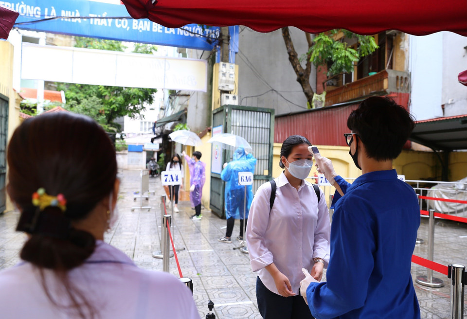  Đo thân nhiệt thí sinh tại điểm thi Trường THCS Hà Huy Tập (quận Hai Bà Trưng). (Ảnh: Hoàng Hiếu/TTXVN)