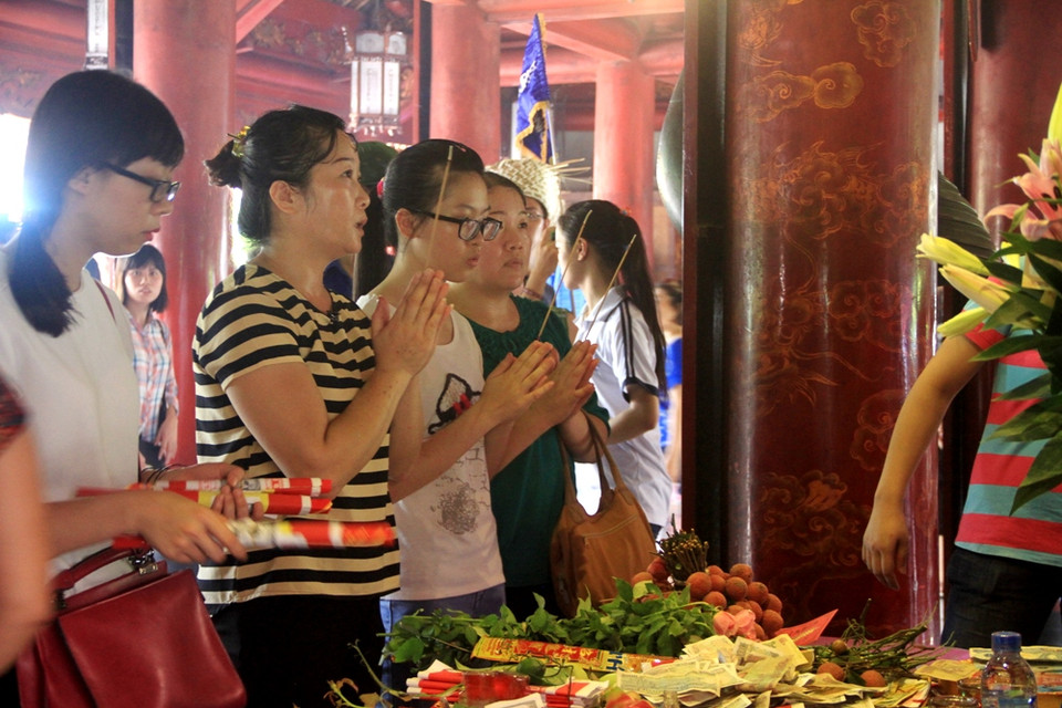 Mẹ con cùng cầu nguyện... (Ảnh: Xuân Mai/Vietnam+)