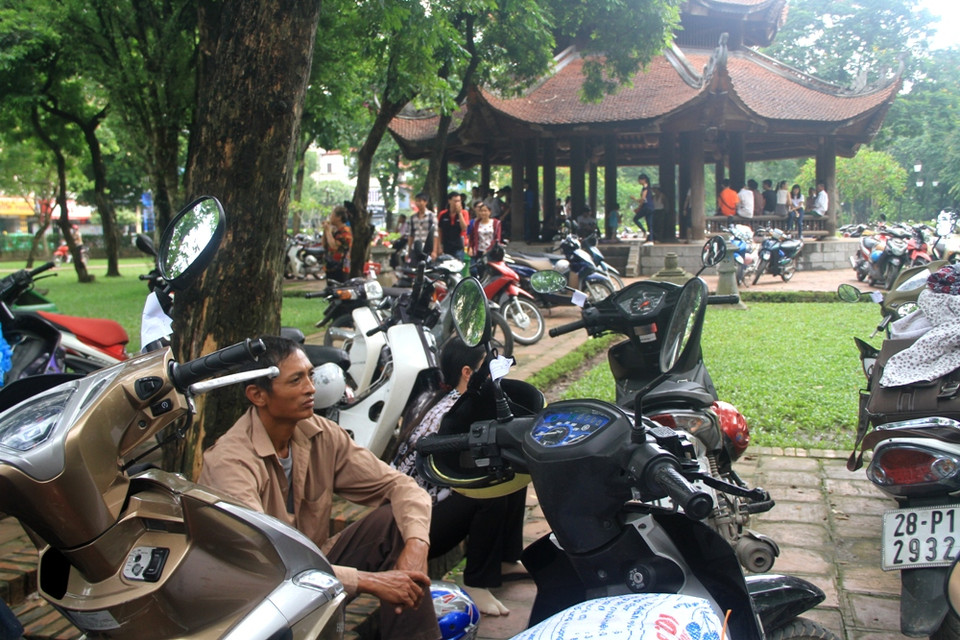 Phụ huynh ngồi đợi con. (Ảnh: Xuân Mai/Vietnam+)