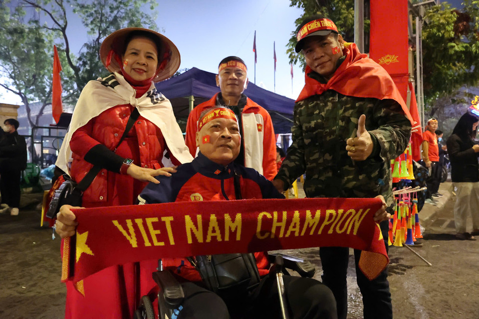 Cổ động viên Đinh Anh Tuấn (giữa) ngồi trên chiếc xe lăn đến sân Việt Trì để cổ vũ Đội tuyển Việt Nam: "Tôi chưa bỏ lỡ một trận đấu nào trên sân nhà của Đội tuyển." (Ảnh: Hoài Nam/Vietnam+)