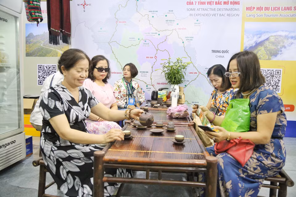 Khách tham quan thích thú thưởng thức đặc sản trà mạn được giới thiệu tại hội chợ. (Ảnh: Nhật Lam/Vietnam+)