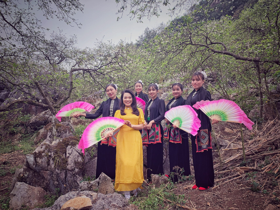 Đội múa chụp hình lưu niệm với du khách đến từ Hà Nội. (Ảnh: Xuân Mai/Vietnam+)