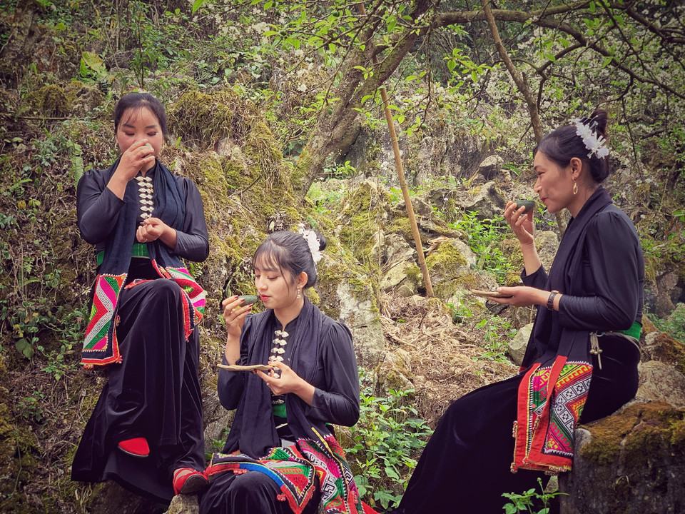 Những cô gái Thái thưởng thức trà cùng nghệ nhân Cao Sơn.(Ảnh: Xuân Mai/Vietnam+)