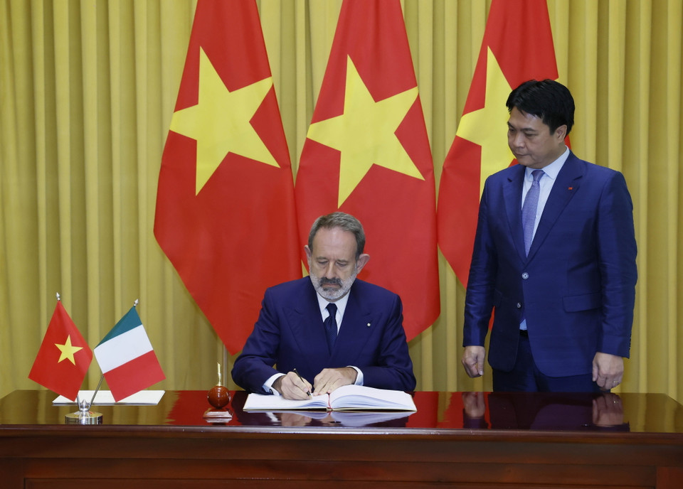 Đại sứ Cộng hòa Italy Marco Della Seta viết lưu bút. (Ảnh: Thống Nhất/TTXVN)