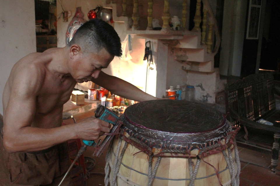 Bưng trống là công đoạn khó khăn nhất với việc căng tròn da trâu lên bề mặt trống rồi dùng đinh bằng tre đóng cố định vào thân trống. (Ảnh: Phương Anh/TTXVN)