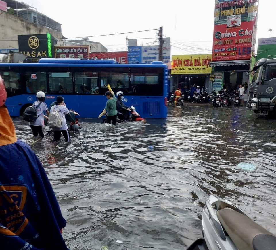 Đường Đỗ Xuân Hợp, thành phố Thủ Đức chìm trong “biển nước”, một xe buýt bị nước ngập hơn nửa bánh xe chết máy ngay giữa đường. (Ảnh: Hồng Giang/TTXVN)