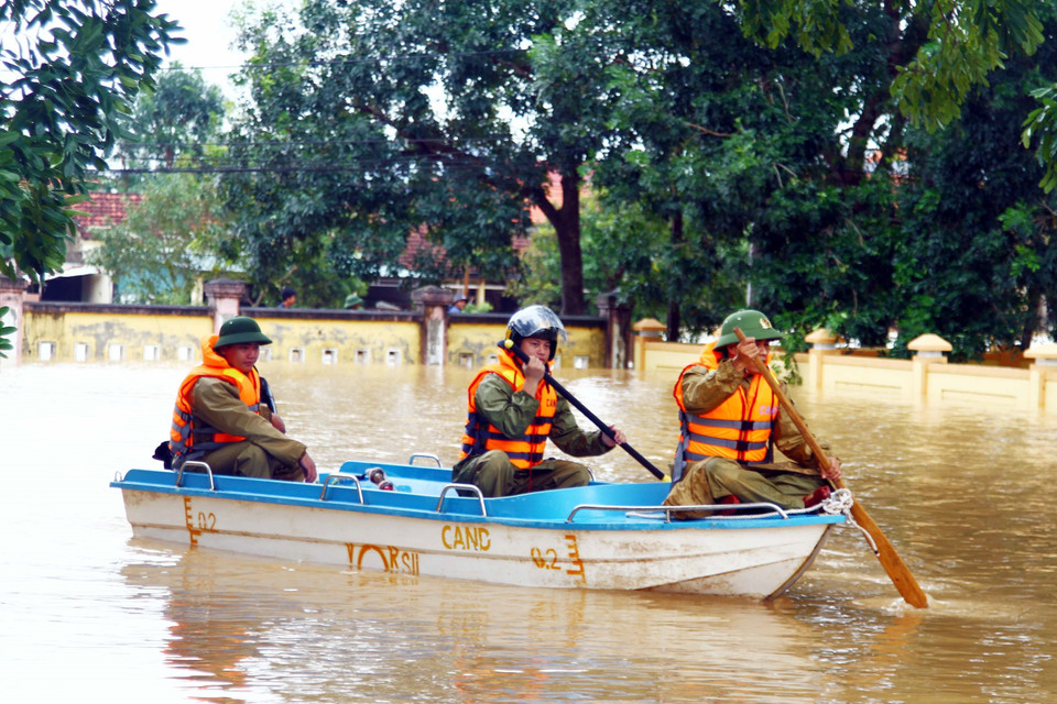 Lực lượng Công an xã An Thủy, huyện Lệ Thủy, Quảng Bình kiểm tra, nắm tình hình tại các khu dân cư bị ngập lụt. (Ảnh: Tá Chuyên/TTXVN)