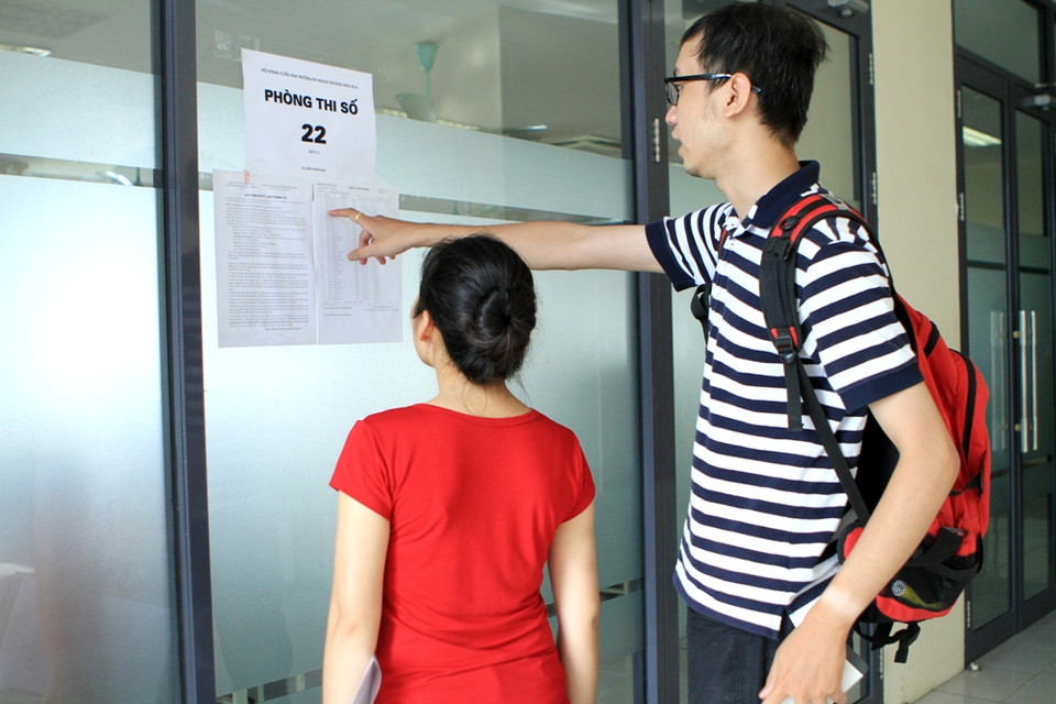 Tìm số báo danh trước khi vào phòng làm thủ tục. (Ảnh: Xuân Mai/Vietnam+)