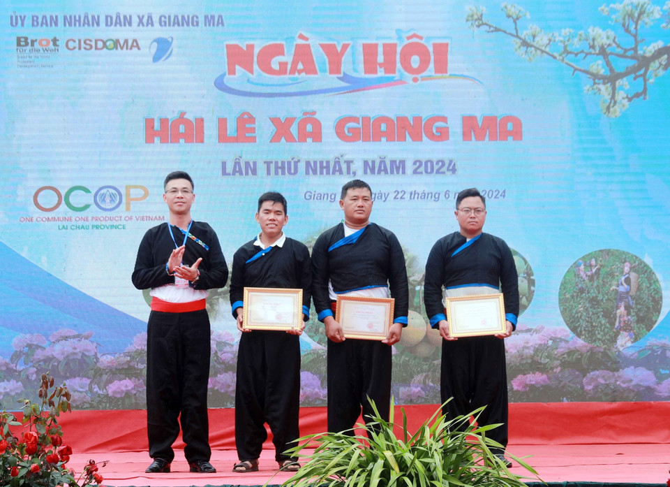 Ban tổ chức trao Giấy Chứng nhận tôn vinh cho 3 hộ gia đình có thành tích tiêu biểu trong công tác trồng, chăm sóc và phát triển cây lê trên địa bàn xã Giang Ma. (Ảnh: Quý Trung/TTXVN)