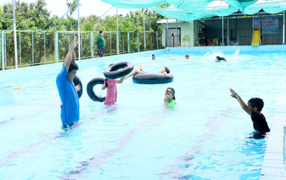Giáo viên hướng dẫn kỹ thuật bơi cho thiếu nhi. (Ảnh: Lê Thúy Hằng/TTXVN)