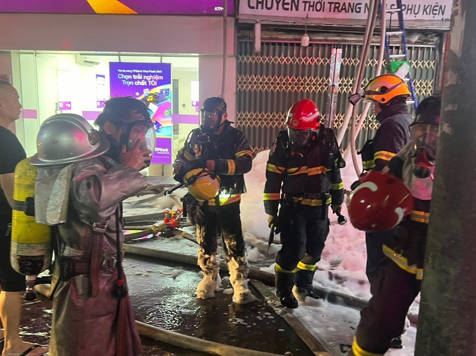 Lực lượng Phòng cháy Chữa cháy mặc quần áo chống lửa để tiếp cận hiện trường, tìm kiếm nạn nhân vụ cháy. (Ảnh: Phạm Kiên/TTXVN)