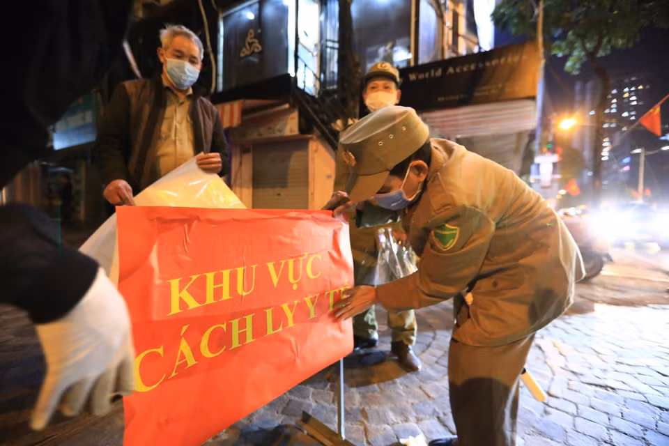 Lực lượng phường Láng Hạ dán biển thông báo cách ly tòa nhà (Ảnh chụp lúc 18h30). (Ảnh: Thành Đạt/TTXVN)
