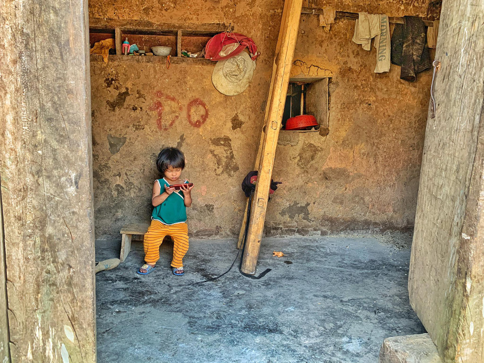 Giờ đây, công nghệ đã len lỏi vào mọi ngõ ngách của đời sống bà con dân bản. Cha mẹ bận lên nương chỉ cần để con ở nhà với chiếc điện thoại thông minh. (Ảnh: Xuân Mai/Vietnam+)