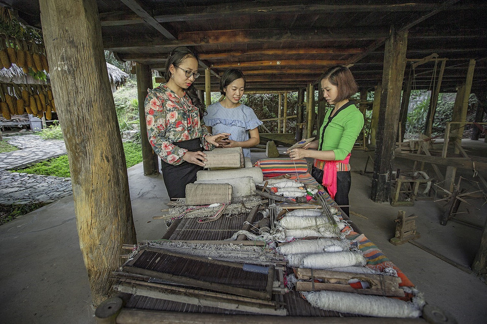 Du khách đến đây không chỉ tham quan mà còn được chiêm ngưỡng những sản phẩm mỹ nghệ của các nghệ nhân và hòa mình vào cuộc sống của người Mường… (Ảnh: Trọng Đạt/TTXVN)