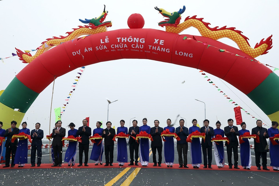  Phó Thủ tướng Trịnh Đình Dũng cùng các đại biểu thực hiện nghi thức cắt băng thông xe Dự án sửa chữa cầu Thăng Long. (Ảnh: Phan Tuấn Anh/TTXVN)