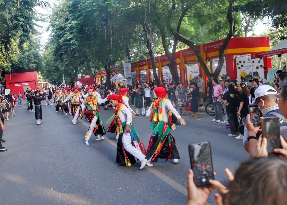 Khách tham quan được thưởng thức điệu múa Bồng (dân gian gọi là múa 'Con đĩ đánh bồng') trên tuyến phố đi bộ Trần Nhân Tông. (Ảnh: Tuấn Đức/TTXVN)
