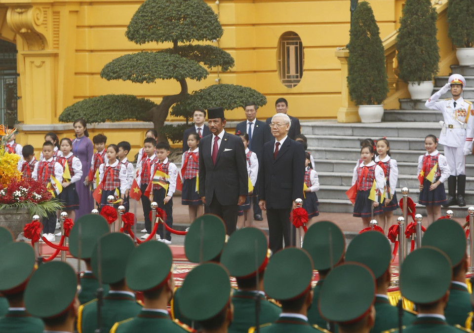 Tổng Bí thư, Chủ tịch nước Nguyễn Phú Trọng và Quốc vương Brunei Hassanal Bolkiah trên bục danh dự nghe Quân nhạc cử Quốc thiều hai nước. (Ảnh: Lâm Khánh/ TTXVN)