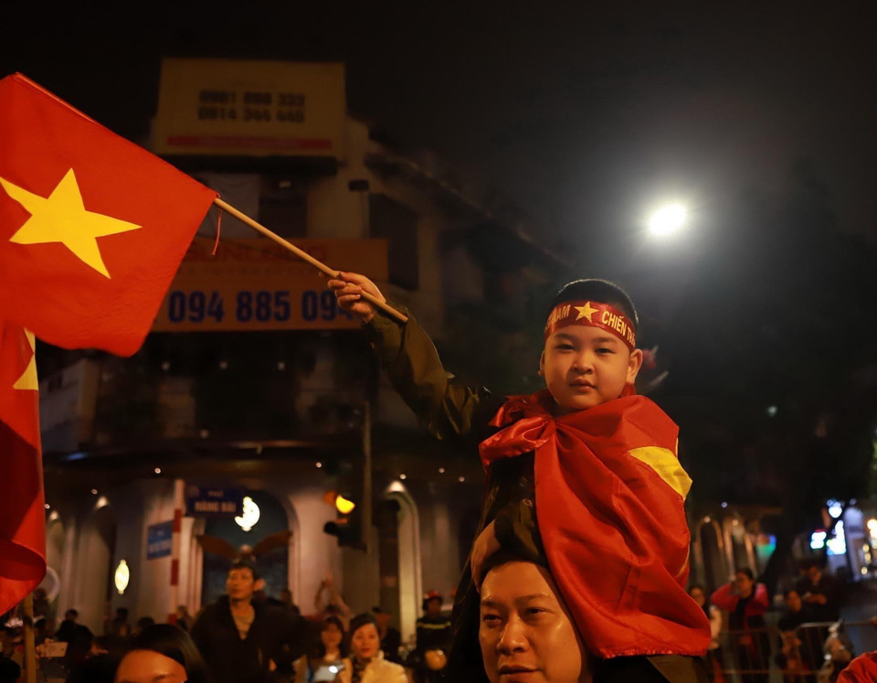 Cổ động viên nhí cổ vũ chiến thắng của đội tuyển bóng đá U23 Việt Nam tại ngã tư phố Hai Bà Trưng-Hàng Bài, Hà Nội. (Ảnh: Hoàng Hùng/TTXVN)