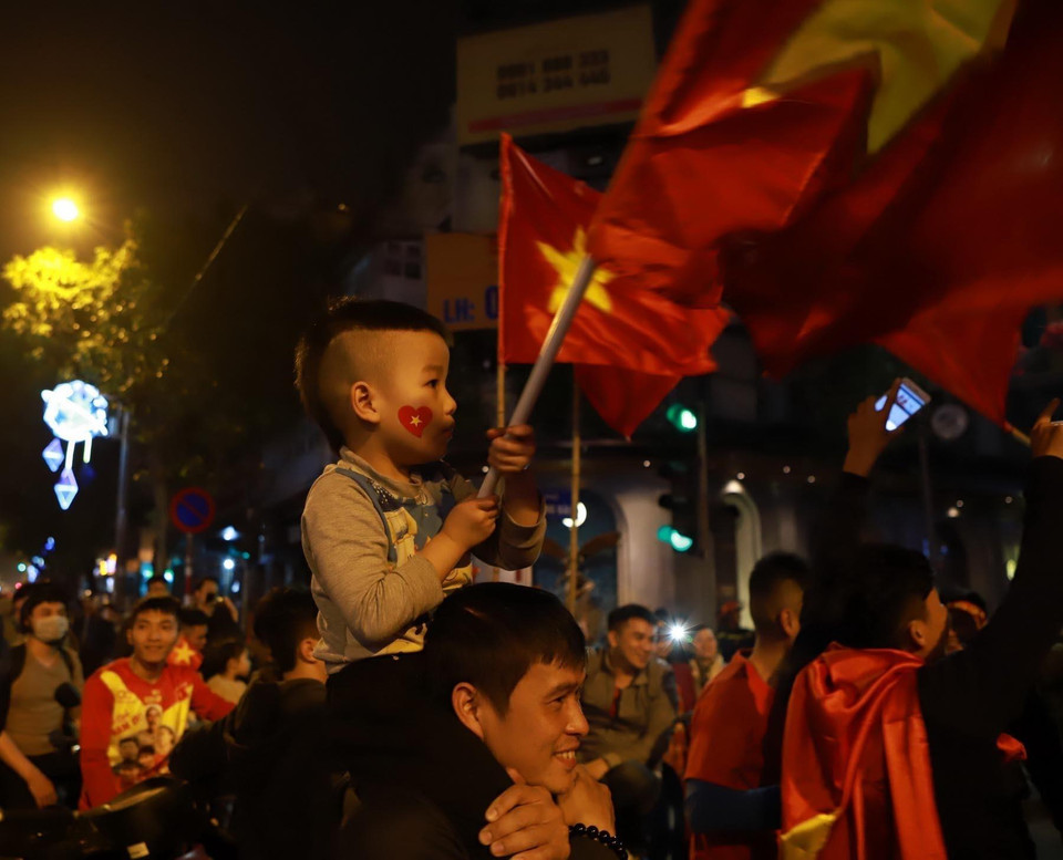 Cổ động viên nhí cổ vũ chiến thắng của đội tuyển bóng đá U23 Việt Nam tại ngã tư phố Hai Bà Trưng-Hàng Bài, Hà Nội. (Ảnh: Hoàng Hùng/TTXVN)