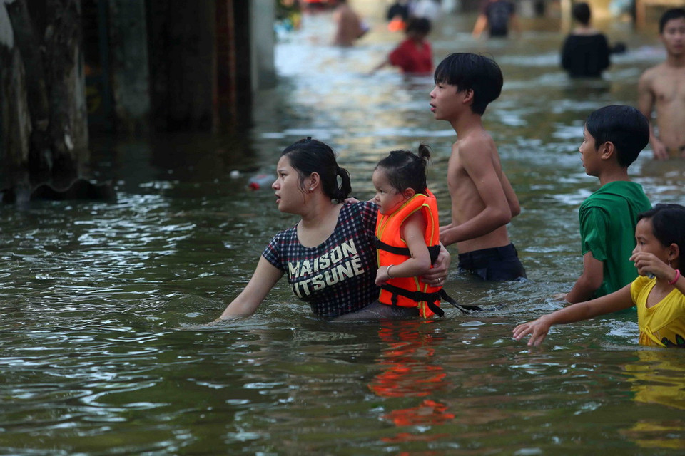 Lực lượng chức năng huyện Quốc Oai đưa người dân từ vùng ngập lên chỗ cao an toàn. (Ảnh: Thành Đạt, Huy Hùng/TTXVN)