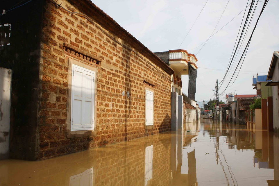 Hơn 100 hộ dân ở làng Bùi Xá đang ngập chìm trong nước. (Ảnh: Thanh Tùng/TTXVN)