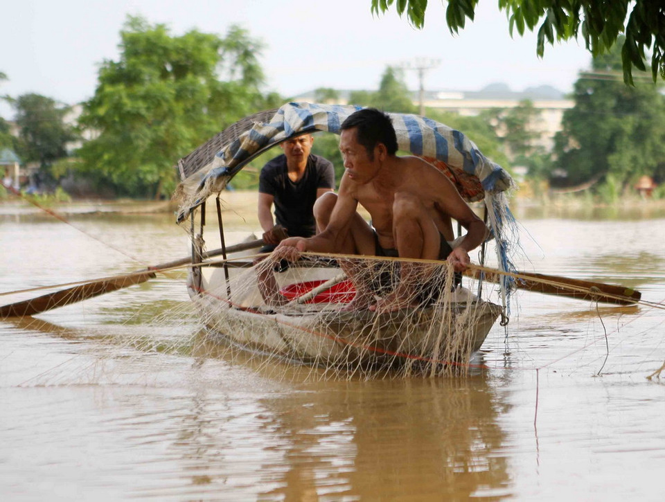 Người dân tranh thủ thả lưới bắt cá. (Ảnh: Thanh Tùng/TTXVN)