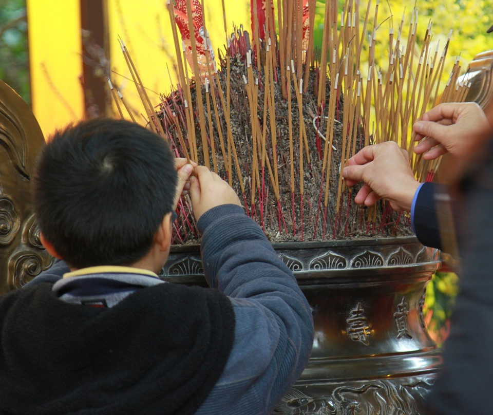 Trong buổi sáng nay, các em nhỏ cũng được cha mẹ đưa đến Điện Kính thiên dâng hương thành kính. (Ảnh: Xuân Mai/Vietnam+)