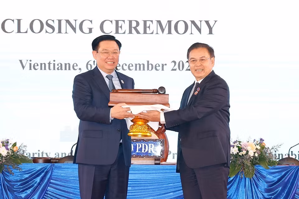 Chủ tịch Quốc hội Vương Đình Huệ nhận búa đảm nhận chức Chủ tịch Hội nghị Cấp cao Quốc hội ba nước CLV lần thứ hai từ Chủ tịch Quốc hội Lào Saysomphone Phomvihane. (Ảnh: Doãn Tấn/TTXVN)