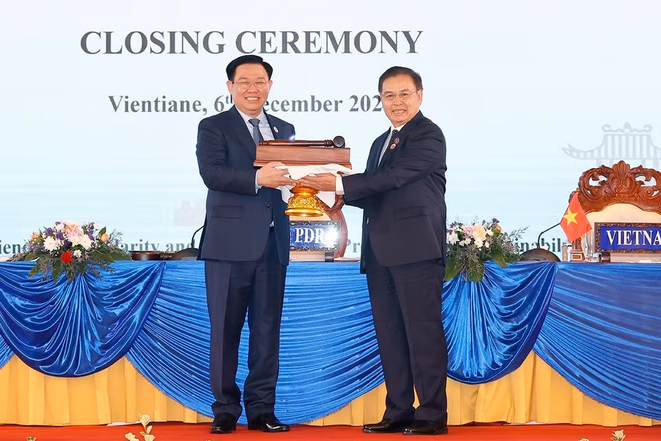 Chủ tịch Quốc hội Vương Đình Huệ nhận búa đảm nhận chức Chủ tịch Hội nghị Cấp cao Quốc hội ba nước CLV lần thứ hai từ Chủ tịch Quốc hội nước Lào Saysomphone Phomvihane. (Ảnh: Doãn Tấn/TTXVN)