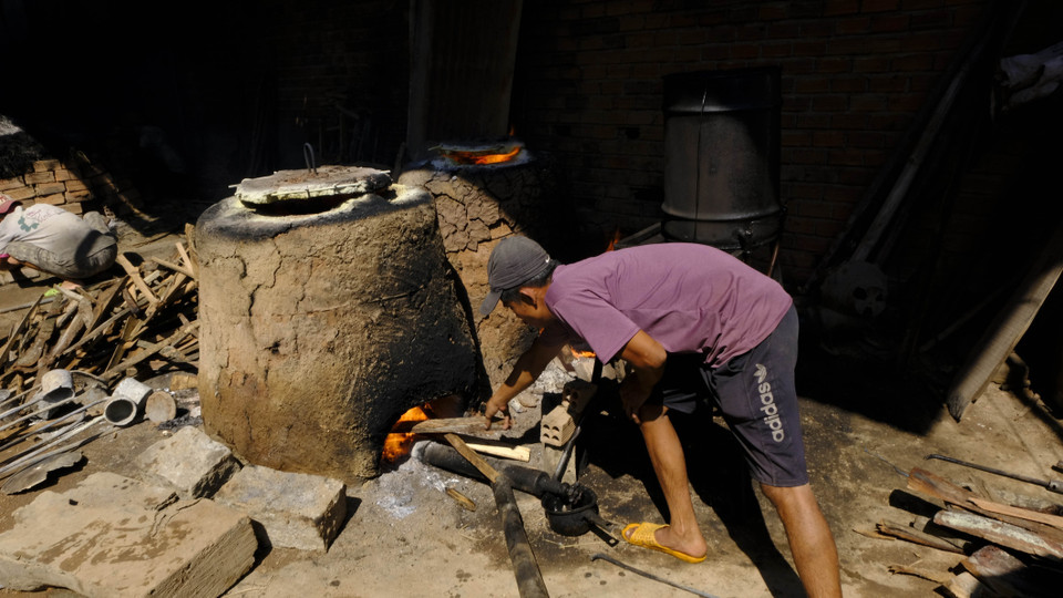 Người lao động chăm sóc nhiệt độ lò nung đồng. (Ảnh: Đặng Tuấn/TTXVN)