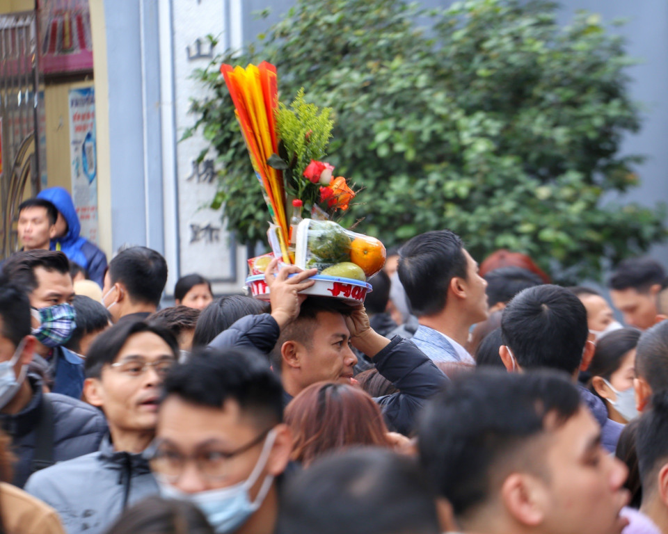 Nhiều người phải đội lễ lên đầu để di chuyển vào trong phủ.(Ảnh: Tuấn Đức/TTXVN)