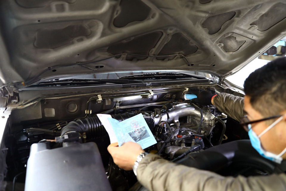 Nhân viên kiểm tra đối chiếu số khung số máy của xe tại Trung tâm Đăng kiểm 29-03V, trên đường Cầu Giấy. (Ảnh: Huy Hùng/TTXVN)