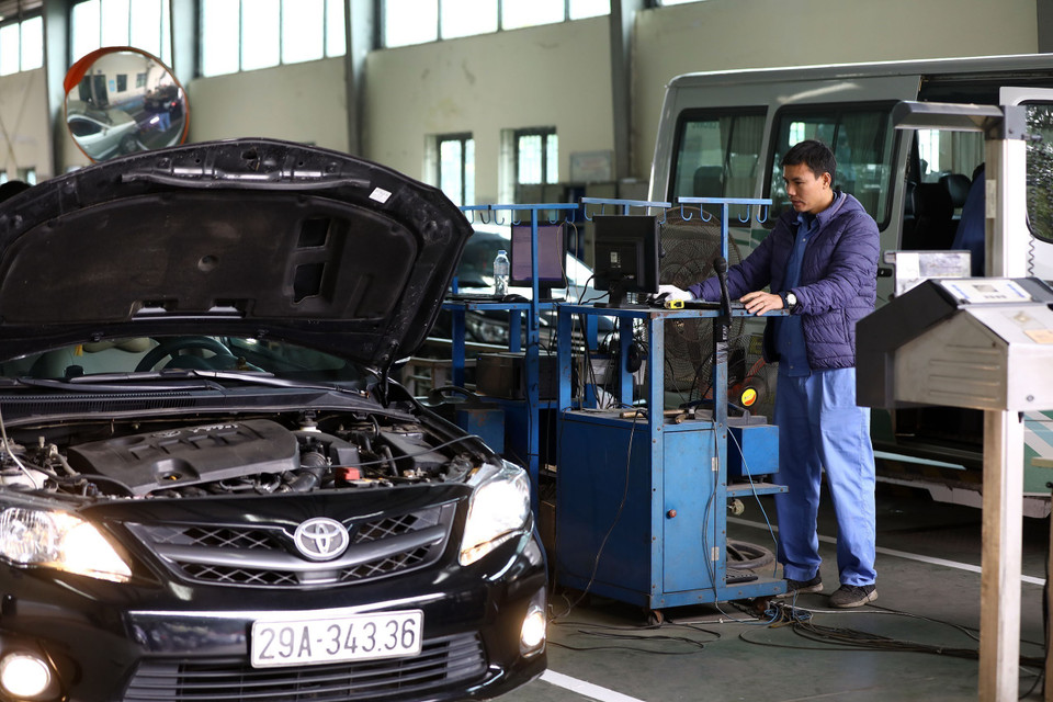 Nhân viên đăng kiểm thực hiện quy trình kiểm định xe. (Ảnh: Huy Hùng/TTXVN)