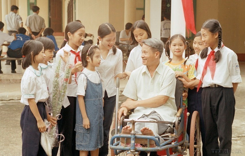 Trẻ em Làng SOS Hà Nội thăm hỏi thương binh Lê Văn Nhốt, thương binh hạng 1/4 tại Trung tâm điều dưỡng thương binh Thuận Thành (Bắc Ninh) (2003). (Ảnh: Dương Ngọc/TTXVN)
