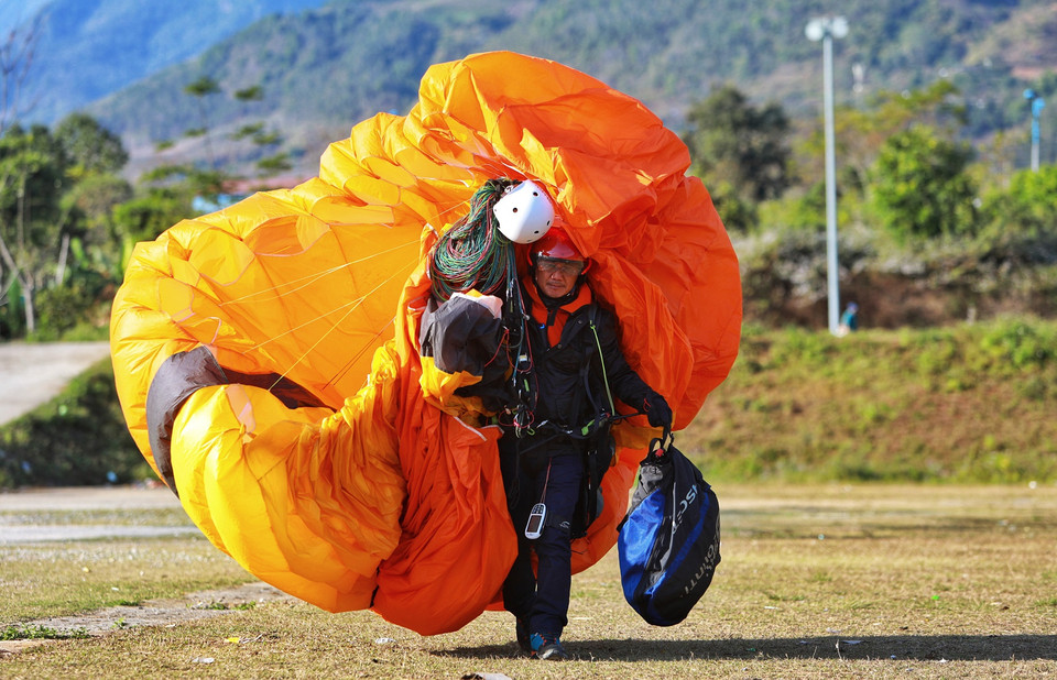 Các phi công dù lượn hỗ trợ nhiệt tình các người đẹp trong lần đầu trải nghiệm cảm giác mạnh. (Ảnh: Quỷ Cốc Tử/Vietnam+)