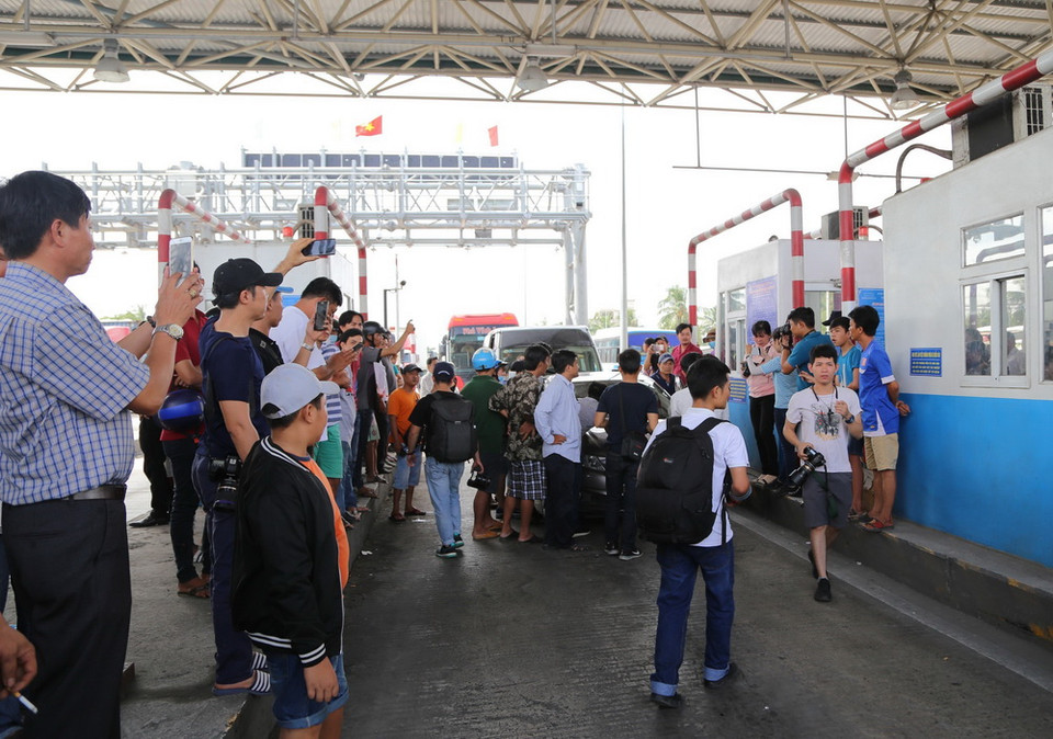 Số lượng lớn tài xế và người dân bức xúc với BOT ùa xuống làn xe. (Ảnh: Nam Thái/TTXVN)