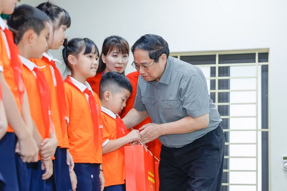 Thủ tướng Phạm Minh Chính tặng quà cho trẻ em khuyết tật tại Trung tâm Nuôi dưỡng trẻ khuyết tật Hà Nội. (Ảnh: Dương Giang/TTXVN)