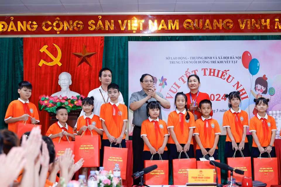 Thủ tướng Phạm Minh Chính tặng quà cho trẻ em khuyết tật tại Trung tâm Nuôi dưỡng trẻ khuyết tật Hà Nội. (Ảnh: Dương Giang/TTXVN_