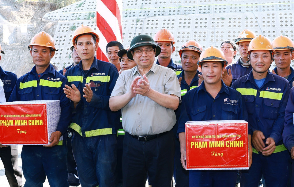 Thủ tướng Phạm Minh Chính tặng quà công nhân thi công hầm Tuy An thuộc Dự án Cao tốc Chí Thạch-Vân Phong. (Ảnh: Dương Giang/TTXVN)